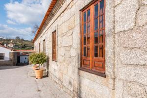 a stone building with a wooden door and potted plants at Casa do Boco in Oliveira do Hospital