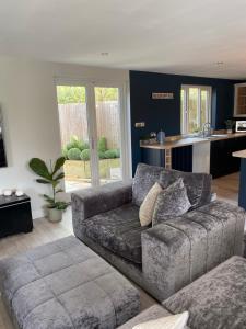 a living room with a couch and a kitchen at Oak Bray Coach House in Bray