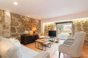 uma sala de estar com uma parede de pedra em Casa do Boco em Oliveira do Hospital