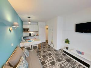 uma sala de estar com um sofá, uma mesa e uma cozinha em Appartement proche Disneyland, Val d'Europe, Paris #2 em Serris