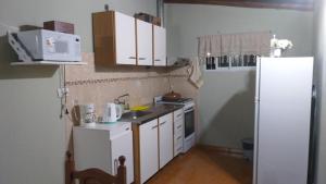 a small kitchen with white cabinets and a refrigerator at Susana in Loncopué