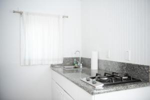 a white kitchen with a stove and a sink at Hermosa Hotel in Avalon