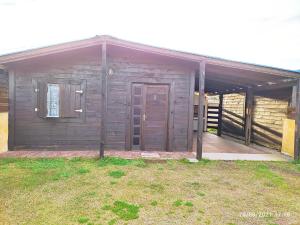 a wooden house with a door and a porch at Las Mozitas 1 in Barra del Chuy