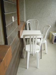 duas cadeiras brancas e uma mesa num quarto em Apartment Grand Vallon em Grimentz