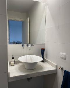 un bagno con un lavandino bianco e uno specchio di Administración MAIPU 3B FI DEPTO PREMIUM a Tandil