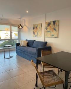 un soggiorno con un divano blu e un tavolo di Administración MAIPU 3B FI DEPTO PREMIUM a Tandil