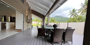 a dining room with a table and chairs on a deck at Sina Pool Villa Rarotonga in Arorangi