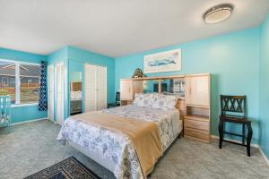 1 dormitorio con paredes azules, 1 cama y 1 silla en Ace's Beach House, en Rockaway Beach