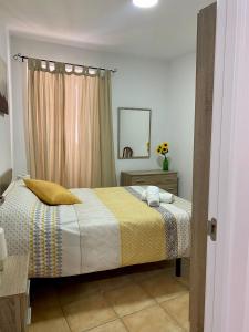 a bedroom with a bed with a yellow and white blanket at APARTAMENTO ARACENA RURAL in Aracena