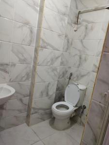La salle de bains est pourvue de toilettes blanches et d'un lavabo. dans l'établissement استديو تشطيب فندقي بالحي الاول, à Ville du 6 Octobre