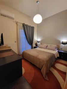 1 dormitorio con cama, escritorio y ventana en Cozy apartment in front of the park en Athens