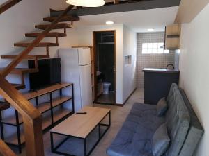 - un salon avec un canapé et un réfrigérateur dans l'établissement Flat Vila Caiçara, à Ilhabela