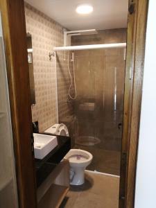 La salle de bains est pourvue d'une douche, de toilettes et d'un lavabo. dans l'établissement Flat Vila Caiçara, à Ilhabela