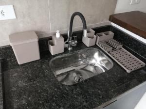 - un évier de cuisine avec un robinet dans un comptoir dans l'établissement Flat Vila Caiçara, à Ilhabela