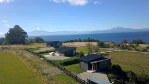 Una vista aérea de una granja con edificios y el océano. en Parcela Nueve, en Frutillar