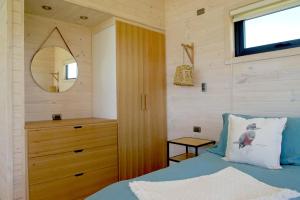 un dormitorio con una cama y un espejo en Parcela Nueve, en Frutillar