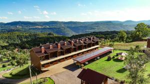 an aerial view of a building with mountains in the background at Stillo Gramado Linha Bonita in Gramado