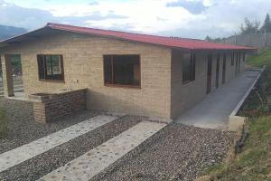 een huis wordt gebouwd in een veld bij Los Lagos in Sutamarchán