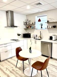 a white kitchen with a table and two chairs at Luxury and cozy 1 Bed Condo in the heart of Providence in Providence