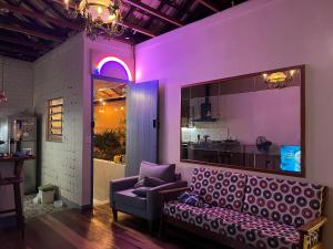a purple room with a couch and a table at Hostel El Caminito LGBTQIAPN plus in Santos
