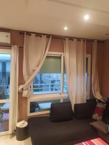 uma sala de estar com um sofá e uma janela em Appartement avec piscine a Dreamland Sidi Rahal em Sidi Rahal