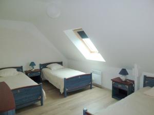 een slaapkamer op zolder met 2 bedden en een dakraam bij Cottage, Le Pouldu in Le Pouldu