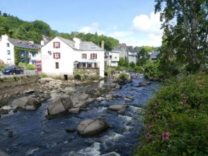 a river with rocks in front of a house at Holiday Home in Doëlan with Sea View in Le Pouldu