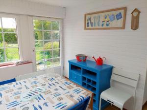 een eetkamer met een blauwe tafel en een blauwe kast bij Breton Granite stone house near the sea, Ploudalmézeau-Portsall in Ploudalmézeau