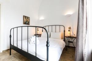 阿克罗蒂里Arcana Santorini Villas, An Authentic Cycladic Experience的一间卧室配有一张黑色的床和一张桌子