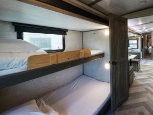 a small room with two bunk beds and a bathroom at Wood Pecker Nakijin in Nakijin