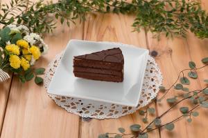 un trozo de pastel de chocolate en un plato en una mesa en Utovilla HOTEL555 沼津店, en Numazu