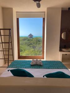 una camera da letto con un letto e una grande finestra di Tikul Hotel Boutique a Isola Holbox