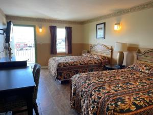 a hotel room with two beds and a desk at Sea Palace Inn in Seaside Heights