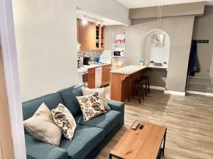 a living room with a blue couch and a kitchen at Mount Vernon Apartment Rear in Baltimore