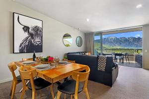 a dining room with a table and a cow on the wall at Tahuna Views in Queenstown