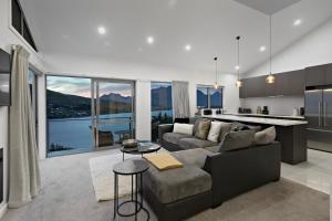 a living room with a couch and a kitchen at Bluewater Views in Queenstown