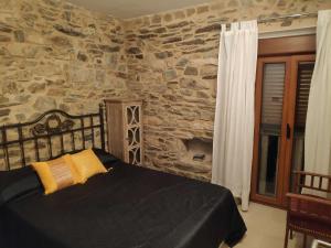 Un dormitorio con una cama con una pared de piedra. en Casa Rural Casa Cancela, en Esfarrapa 18 fotos más
