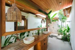 a bathroom with a counter with two sinks and plants at Molokai Suites in Uluwatu