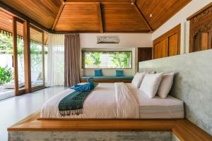 una camera da letto con un letto grande in una stanza di Molokai Suites a Uluwatu Altre 37 foto