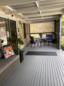 a patio with a table and chairs on a deck at Cozy Cottage Victor Harbor in Hindmarsh Valley