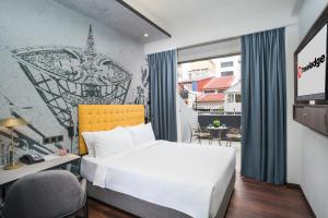 a bedroom with a bed and a desk and a window at Travelodge Chinatown Kuala Lumpur in Kuala Lumpur