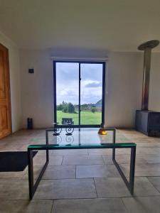 a glass table in a room with a large window at Cabaña Puro Ranco in Lago Ranco
