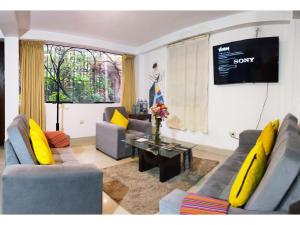 sala de estar con 2 sofás y TV en Runa Apartamentos en Cusco