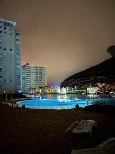 uma grande piscina à noite com edifícios em Laguna Vista Algarrobo em Algarrobo