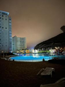 a large swimming pool at night with buildings at Laguna Vista Algarrobo in Algarrobo