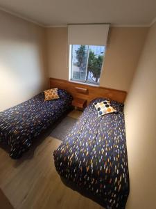 1 dormitorio con 2 camas con sábanas de lunares en Laguna Vista Algarrobo, en Algarrobo