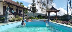 un grupo de personas en una piscina en un complejo en Mapa Lake View Bungalow, en Kintamani