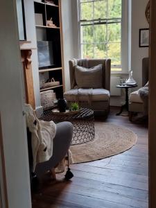 uma sala de estar com uma cadeira e um sofá em 55 Davey Townhouse 1, Salamanca on your doorstep em Hobart