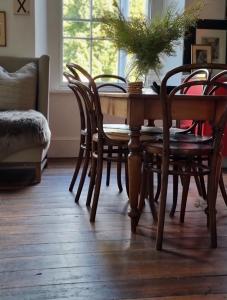uma sala de jantar com uma mesa e cadeiras e uma janela em 55 Davey Townhouse 1, Salamanca on your doorstep em Hobart
