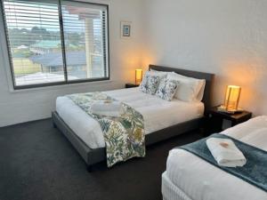 a hotel room with two beds and a window at Vista Marina Penthouse #5 - Amazing views & location in Bermagui